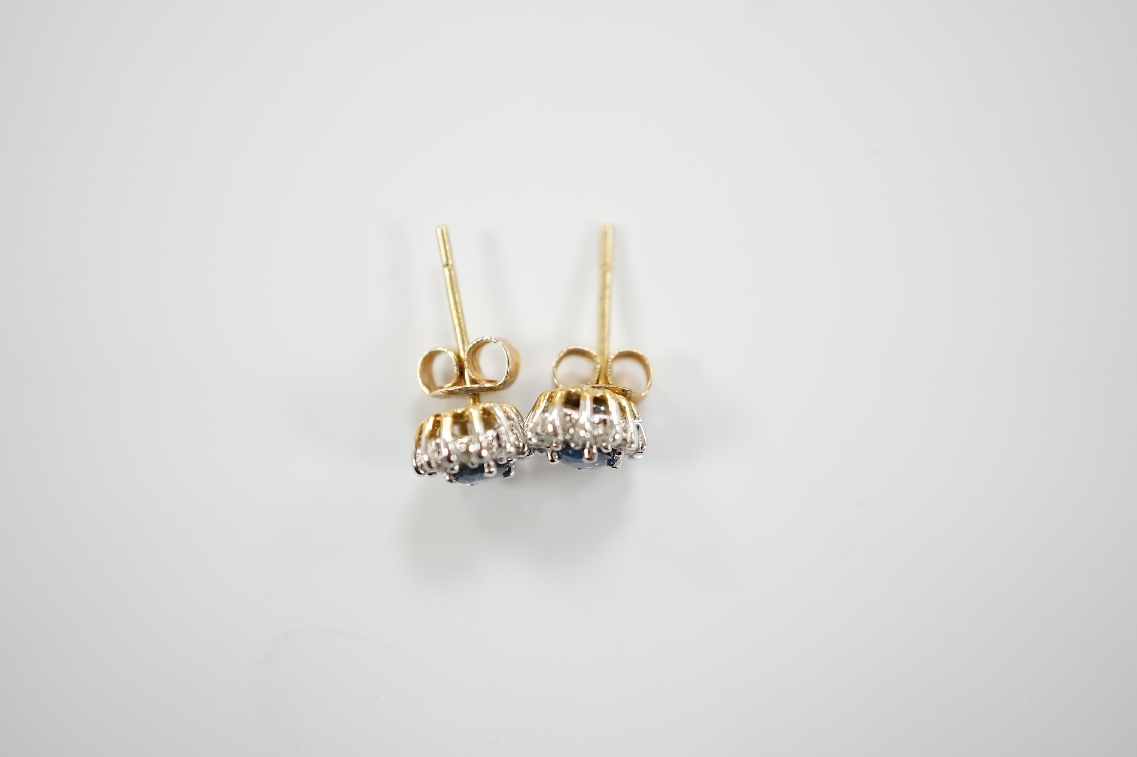 A pair of yellow metal, sapphire and diamond set oval cluster ear studs, 7mm, gross weight 1.3 grams.
